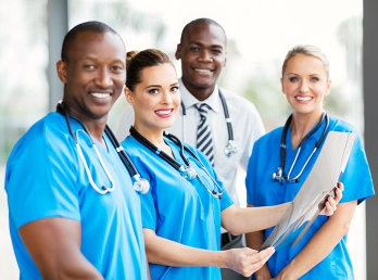 medical personnel holding a paper smiling at the camera